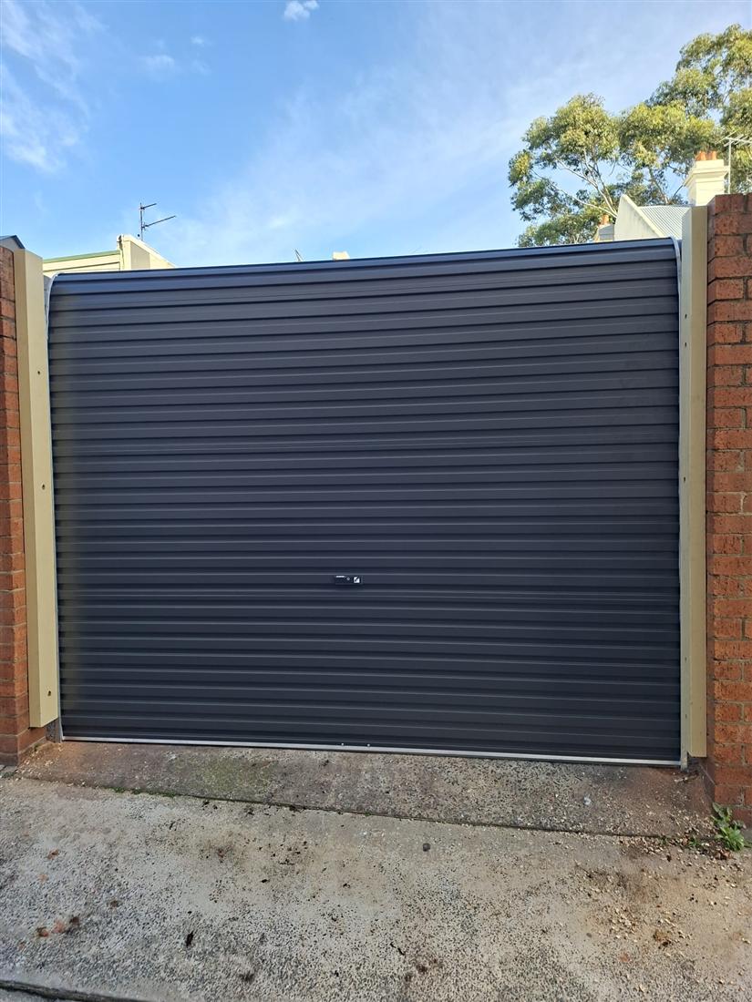 Charcoal roller door installed in a brick opening