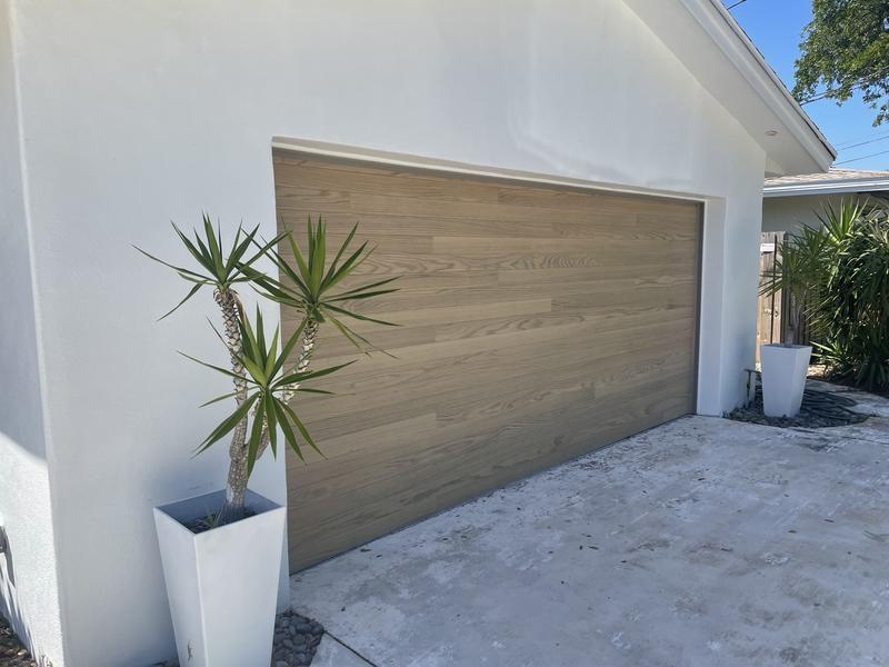 Wood-tone sectional garage door on a stucco home